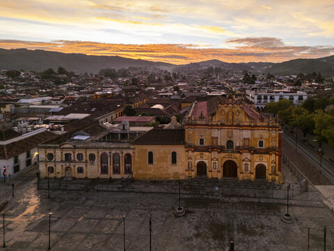 Aerial view of the historic Cathedral of San Cristobal de las Casas at sunrise, surrounded by colonial rooftops and mountains in San Cristobal de las Casas, Chiapas, Mexico.