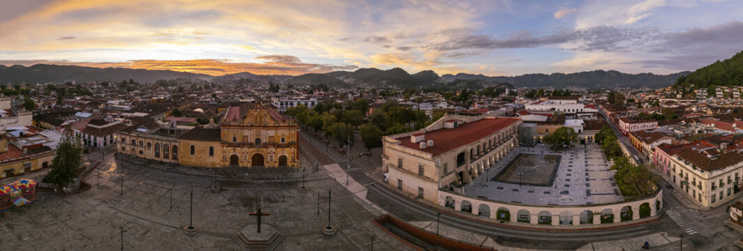 Aerial view of the Cathedral and Plaza de la Paz at sunrise, with colonial rooftops and warm light over the city. San Cristobal de las Casas, Chiapas, Mexico.