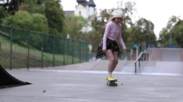 Stylish woman riding skateboard in skate park