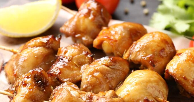 Delicious shish kebabs with spices and tomatoes on wooden table, closeup. Camera moving down