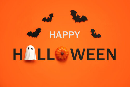 Happy Halloween. Top view of ghost and pumpkin forming the text Happy Halloween with bats
