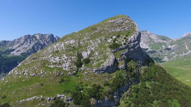Aerial view of Bobotov Kuk peak with rocky slopes and green vegetation in Zabljak Municipality, Montenegro.