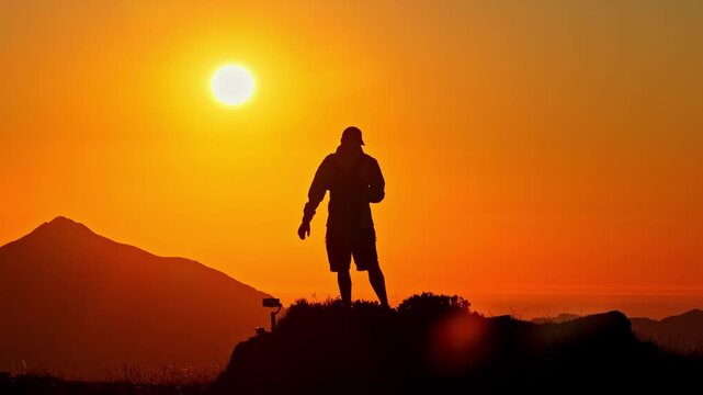 Person silhouetted on Col d&rsquo;Aubisque peak, sunrise, aerial telephoto view, scenic Pyrenees