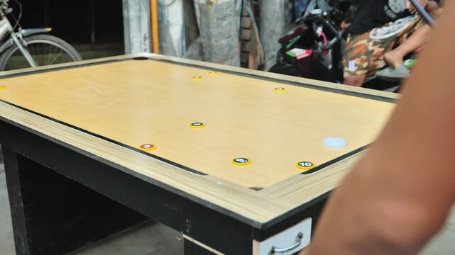 Locals enjoy a wooden carambola table game in Happyland, Tondo, Manila