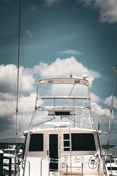 Upper deck of modern superyacht and masts against cloudy sky