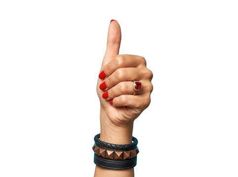Primo piano di una mano femminile che mostra il gesto del pollice in su, con unghie smaltate di rosso brillante, un anello con pietra preziosa e bracciali in pelle, isolata su sfondo bianco puro.