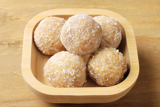 Traditional Brazilian beijinho coated in shredded coconut, served in a bamboo bowl. A dessert for parties and birthdays.