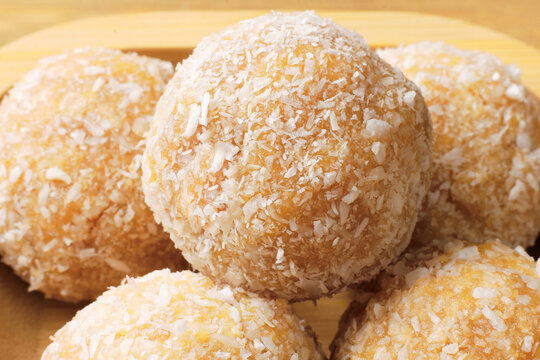 Closeup of a traditional Brazilian coconut beijinho on a wooden table. homemade party treat
