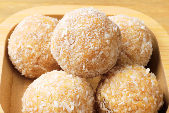 Brazilian coconut beijinho coated in shredded coconut. A dessert for parties, celebrations, and confectionery shops.