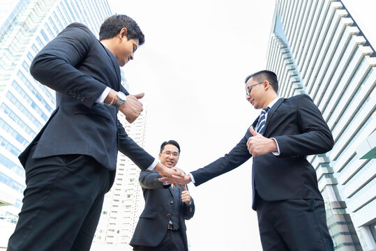 Happy asian business people team winners laughing give high five together join hands celebrating connection spirit good relation, successful teamwork victory, unity and teambuilding.teamwork
