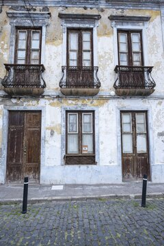 Weathered fa&ccedil;ade of an empty house in Garachico, characterized by crumbling plaster, old wooden doors and wrought-iron balconies, a silent testimony of past times, Garachico, Tenerife, Canary Islands, Spain