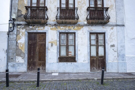 Weathered fa&ccedil;ade of an empty house in Garachico, characterized by crumbling plaster, old wooden doors and wrought-iron balconies, a silent testimony of past times, Garachico, Tenerife, Canary Islands, Spain