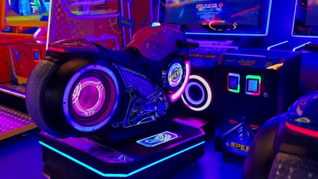 Empty neon motorcycle simulator inside a dark indoor amusement arcade. Bright purple and blue LED lights illuminate the interactive racing machine waiting for players in the gaming center.