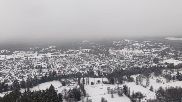 Aerial Wide Establishing of Snow Covered Melipeuco Town Misty Winter Mountains Chile