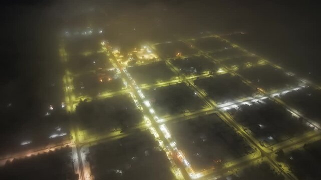 Aerial Night Drone of Dense Fog Over Illuminated Snowy Town Melipeuco Chile Cityscape