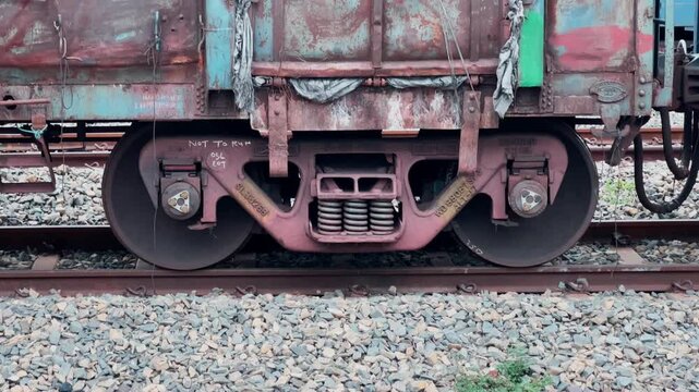 Tilt up shot revealing the cast steel CASNUB bogie coil springs roller bearings and safety marking beneath a weathered freight wagon