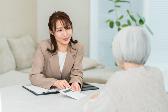 シニア女性の住まいの相談に応じる住宅メーカーの女性営業スタッフ