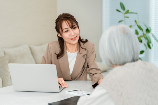 シニア女性の相談を受けるジャケット姿のビジネスウーマン