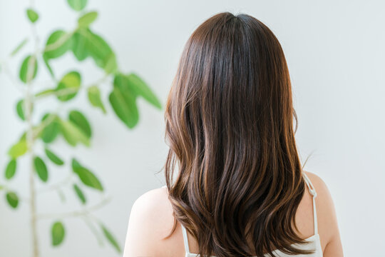 A woman with long hair, seen from behind, a natural hair care image.
