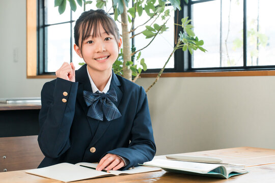Elementary, middle, and high school girls in their school uniforms studying at home