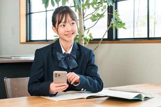 Middle school, high school, and elementary school girls use their smartphones at home to study, do homework, and study in the living room.