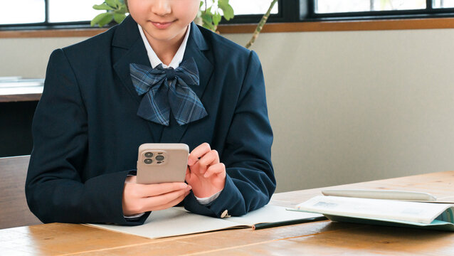 Middle school, high school, and elementary school girls use their smartphones at home to study, do homework, and study in the living room.