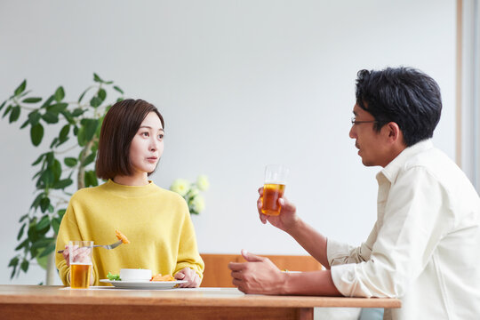お酒を呑みながら食事をする女性と男性