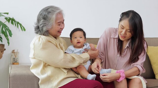 Grandmother and mother gently caring for a baby boy together at home, representing family love, maternal support, intergenerational bonding, and the joy of raising a child.