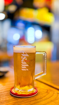 Bangkok, Thailand - 7 Aug 2026: A glass of Asahi beer on the table at a restaurant.