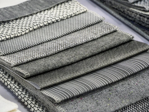 Close-up and layered stacking of textile fabric samples in various gray textures