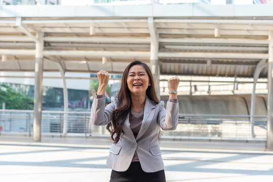 Business woman in suit look to future on building background in city outdoor and celebrating for success work at the office, investment concept, success concept