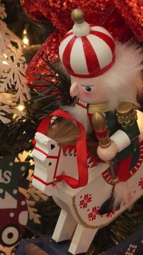 Close-up of Christmas decoration with nutcracker riding horse and car on illuminated tree. 4k.