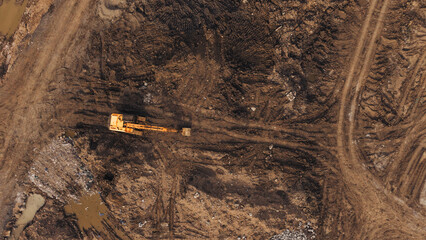 Excavator plowing dark churned soil at land clearing construction site industrial earthmoving development © VisualTreat12