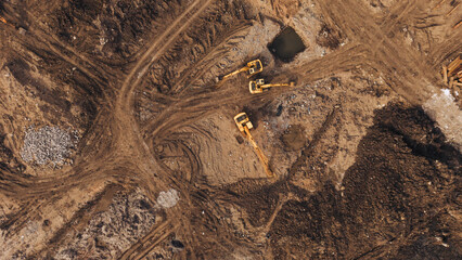 Excavator on dirt access road at active construction earthworks site industrial land development © VisualTreat12
