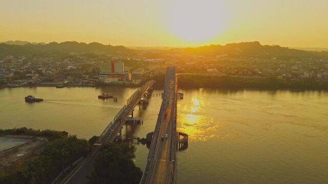 Aerial view of Mahakam Bridge spanning the Mahakam River during golden hour in Samarinda, Kalimantan Timur, Indonesia.