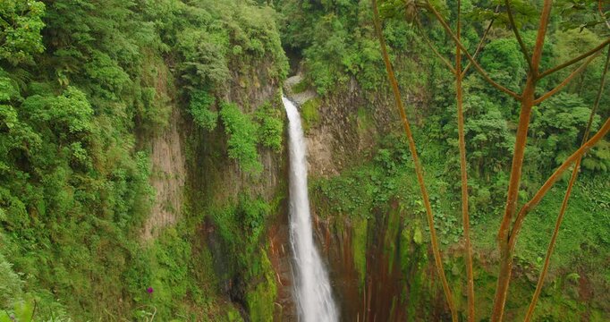 Towering waterfall Catarata del Toro descending into lush canyon in Costa Rica during scenic travel