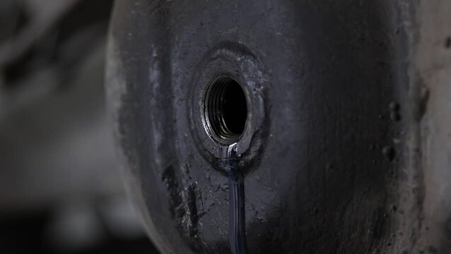 Golden gear oil flows through tube into car differential housing.