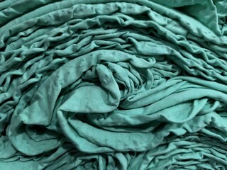 Fototapeta premium Close-up of folded green fabric with texture details