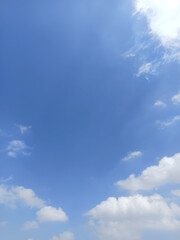 Obraz premium Beautiful blue sky with fluffy white cumulus clouds and delicate wispy clouds, creating a peaceful natural background with ample copy space.