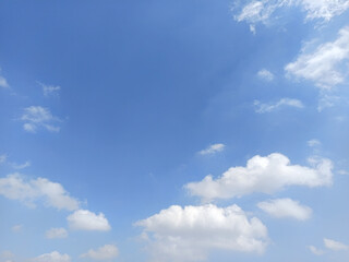 Obraz premium Beautiful blue sky with fluffy white cumulus clouds and delicate wispy clouds, creating a peaceful natural background with ample copy space.