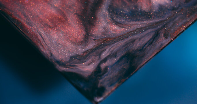 Paint mix. Glitter flow. Defocused blue orange purple color triangle sparkling texture shiny fluid spilling on abstract art background.