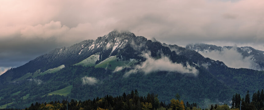 Alps mountain range with clouds covering peaks