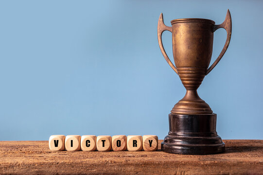 Bronze Trophy with Victory Blocks on Wooden Surface Displayed Elegantly