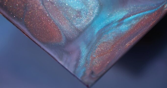 Paint splash. Glitter pigment. Blur blue orange purple color triangle marble blend shiny texture spilling on abstract art background.