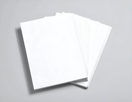 A stack of blank, white rectangular paper sheets fanned out on a plain gray surface