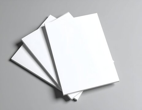 Stack of white rectangular papers, fanned slightly, atop a grey surface
