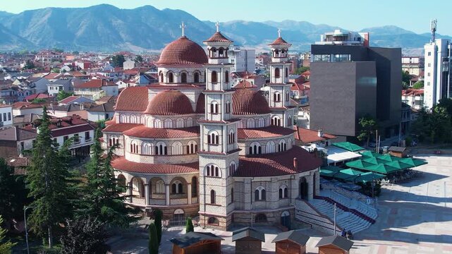 Cathedral surrounded by traditional houses and modern buildings on quiet morning streets in Kor&ccedil;a city