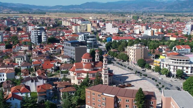Panoramic aerial footage of Kor&ccedil;a city center rooftops traditional houses and modern buildings on morning
