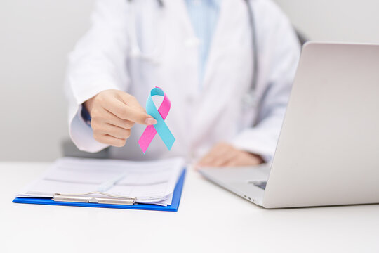 Doctor giving blue and pink ribbon to patient for concept of October male Breast Cancer Awareness month, National Cancer Survivors Month and Pink October Healthcare and February world cancer