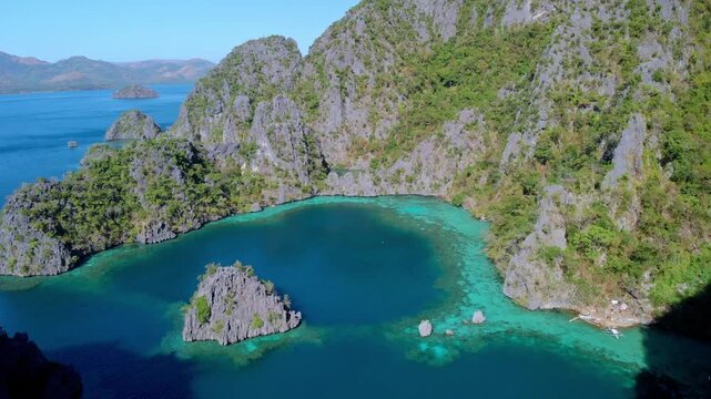 Aerial view of turquoise lagoon surrounded by limestone cliffs and lush vegetation in Palawan, Mimaropa, Philippines.